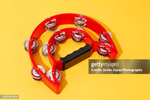 red tambourine on yellow background - tambourine stock pictures, royalty-free photos & images
