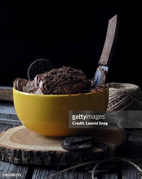 chocolate ice cream sprinkled with chocolate chips in yellow ceramic bowl side view on black background closeup. selective focus - close up of chocolates for sale stock pictures, royalty-free photos & images