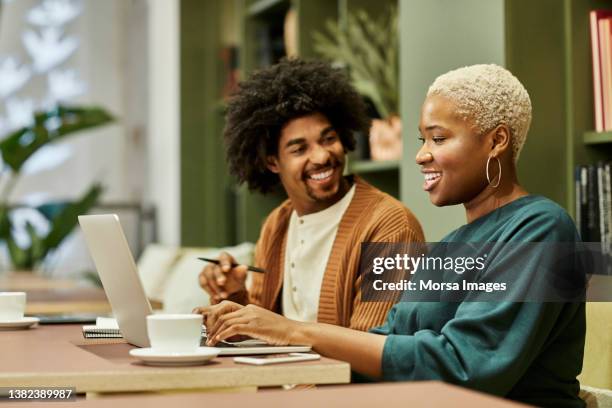 coworkers discussing during meeting in office - black woman laptop stockfoto's en -beelden