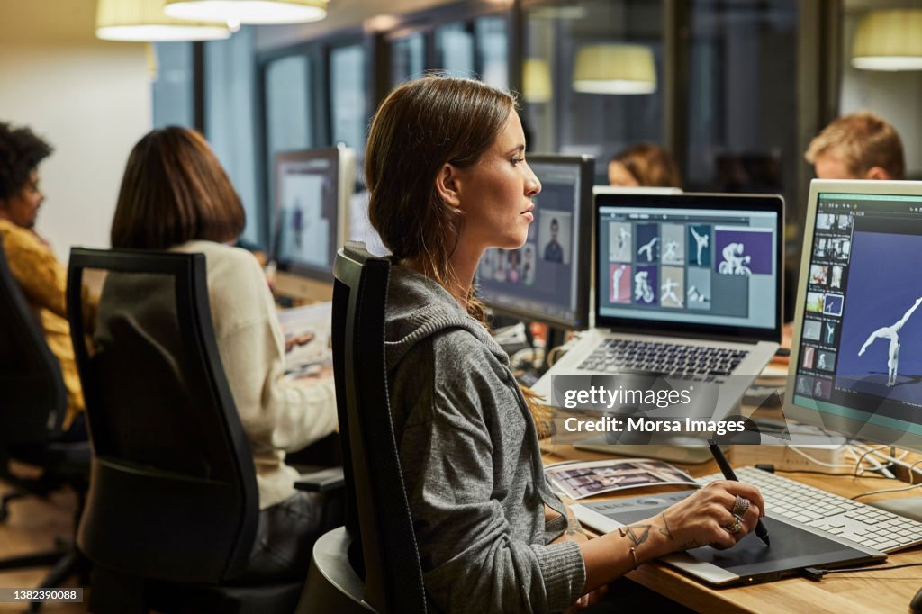 Female graphic designer using computer in office