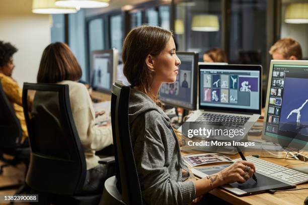 female graphic designer using computer in office - graphic patterns stock-fotos und bilder