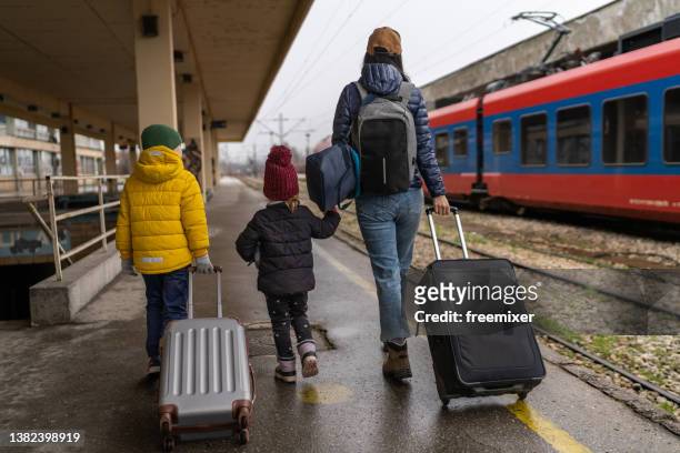 single mother and two small children at the train station - immigrants stock pictures, royalty-free photos & images