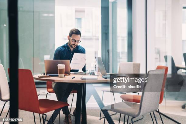 businessman working alone in a glass office - projection stock pictures, royalty-free photos & images