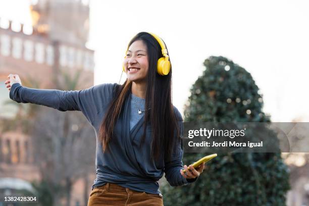 happy young man dancing while listening to music with his mobile - colour street dance stock pictures, royalty-free photos & images