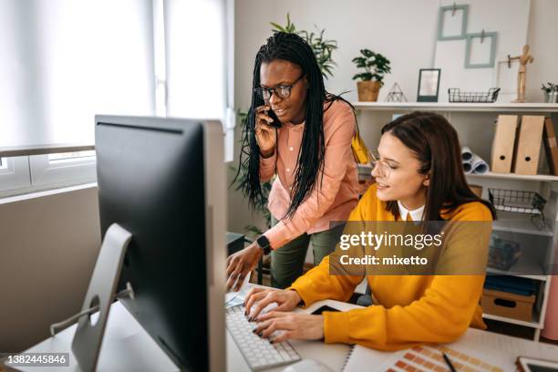 kolleginnen diskutieren am computer im büro - kleines büro stock-fotos und bilder