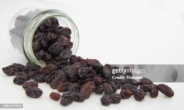 dried raisins against white background - raisin stock pictures, royalty-free photos & images