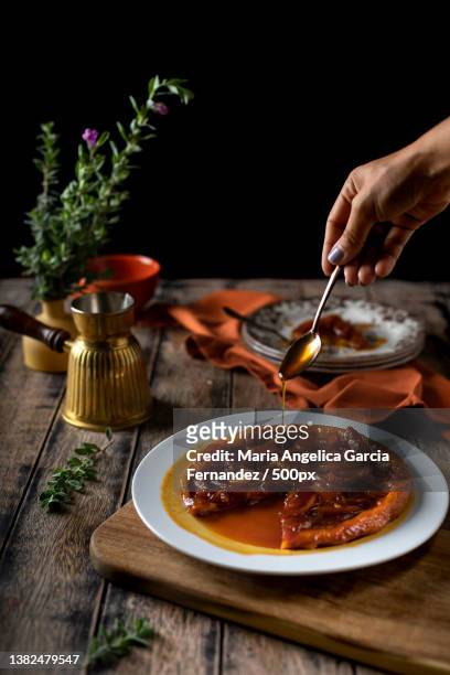 dessert caramel tart,cropped hand pouring honey on table against black background,united arab emirates - maria garcia stock pictures, royalty-free photos & images