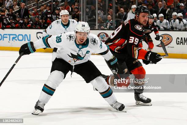 Logan Couture of the San Jose Sharks battles for position against Sam Carrick of the Anaheim Ducks during the game at Honda Center on March 6, 2022...