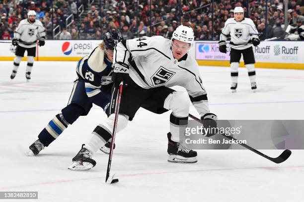 Mikey Anderson of the Los Angeles Kings shields the puck from Patrik Laine of the Columbus Blue Jackets during the second period of a game at...