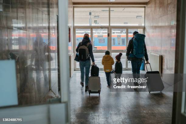 familia con dos hijos en la estación de tren - inmigrante fotografías e imágenes de stock