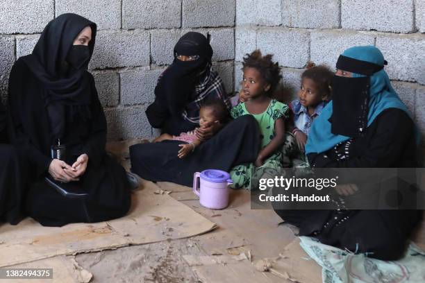 In this handout photo issued by the United Nations High Commission for Refugees, Special envoy Angelina Jolie meets displaced Yemeni people, who fled...