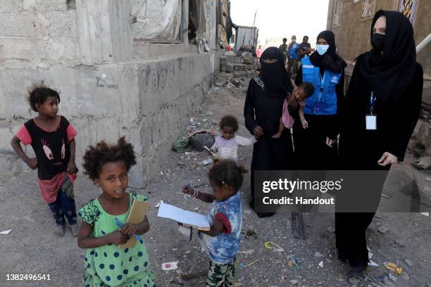 In this handout photo issued by the United Nations High Commission for Refugees, Special envoy Angelina Jolie meets displaced Yemeni people, who fled...