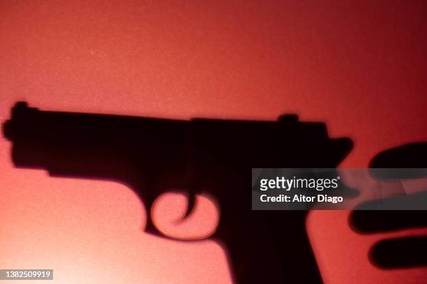 silhouette of a person that is going to take a gun. war concept. - moord stockfoto's en -beelden