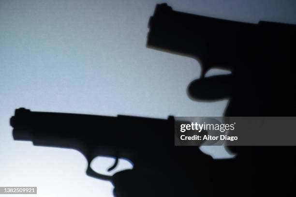 silhouette two persons with guns ready to shoot. war concept. - arma de fogo imagens e fotografias de stock