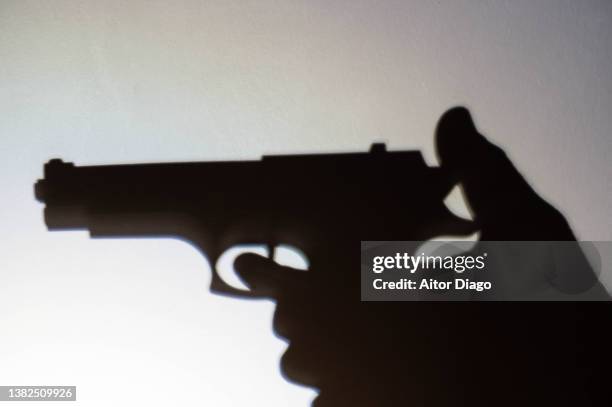 silhouette of a person that is to shoot with a gun. war concept. - arma de fogo imagens e fotografias de stock