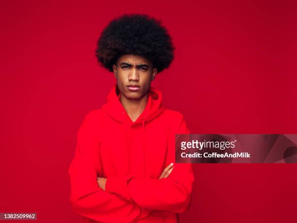 african american man with african hairstyle standing over isolated red background - man and his hoodie imagens e fotografias de stock