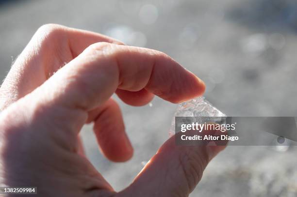 a person holds a piece of ice in his hand. - broken finger ストックフォトと画像