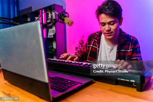 teenage  boy filming videos at home and playing keyboard instrument to camera set on ring light - keyboard white stockfoto's en -beelden