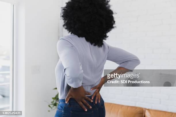 mujer con problemas de espalda baja - restraining fotografías e imágenes de stock