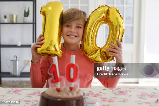 happy boy  with number 10 helium balloons smiling joyfully in birthday party at home - 10 11 years stock pictures, royalty-free photos & images