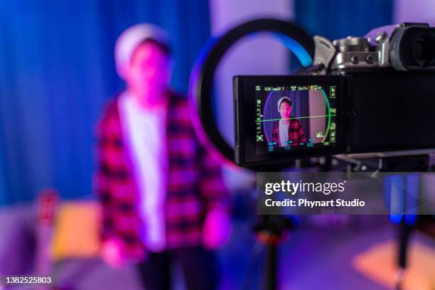 teenage  boy filming videos at home and talking to camera set on ring light - film set stockfoto's en -beelden