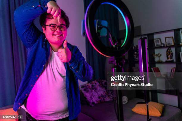 overweight young man filming videos at home and talking to camera set on ring light - generation z icons stock pictures, royalty-free photos & images