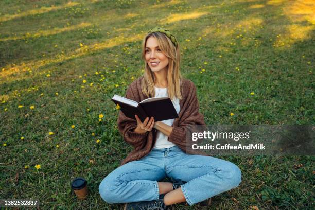 colores brillantes de la naturaleza - mujer leyendo libro en el parque fotografías e imágenes de stock