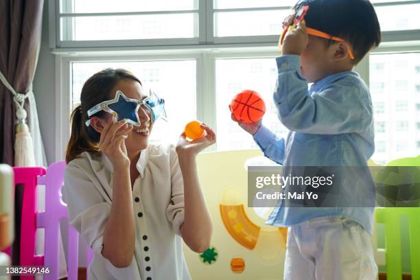 mother and son bonding with fun glasses - child playpen stock pictures, royalty-free photos & images