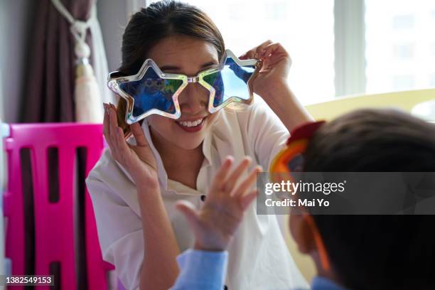 mother and son bonding with fun glasses - child playpen stock pictures, royalty-free photos & images