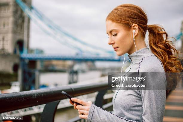 modern athlete using phone - woman headphones sport smile iphone stock pictures, royalty-free photos & images