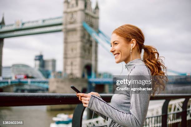 modern athlete using phone - woman headphones sport smile iphone stock pictures, royalty-free photos & images
