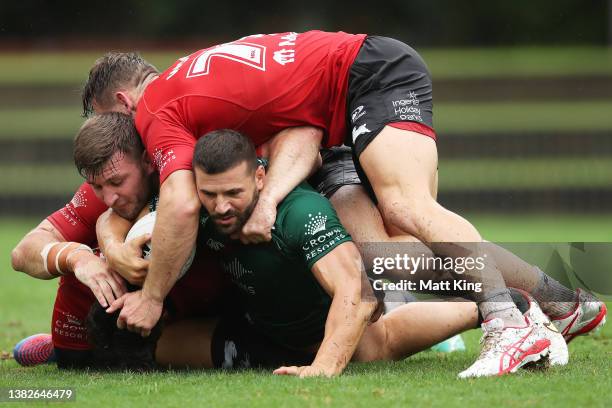 Josh Mansour is tackled during a South Sydney Rabbitohs NRL Training Session at Redfern Oval on March 08, 2022 in Sydney, Australia.