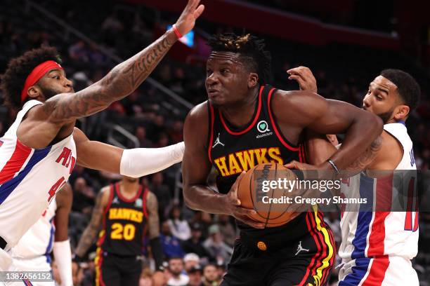 Clint Capela of the Atlanta Hawks tries to get a shot off around Saddiq Bey of the Detroit Pistons during the first half at Little Caesars Arena on...