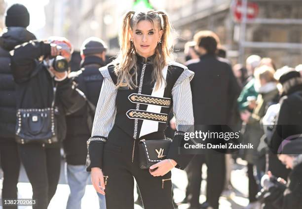 Xenia Adonts is seen wearing a black, white and gold Louis Vuitton top and Louis Vuitton bag outside the Louis Vuitton show during Paris Fashion Week...