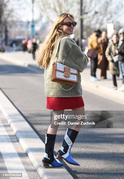 Blanca Miro is seen wearing a green faux fur jacket and brown and white Louis Vuitton bag with Louis Vuitton blue and white boots outside the Louis...