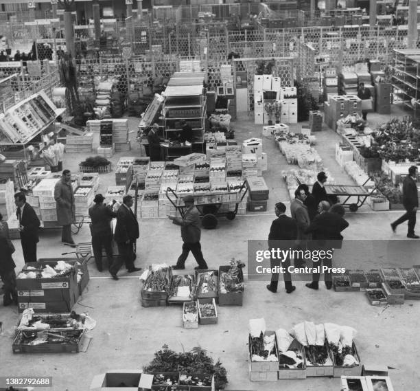 High angle view looking down on buyers and stall holders among porters and boxes of flowers as the flower market of New Covent Garden Market opened...