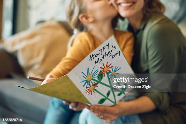 Close-up of woman receiving Mother's day greeting card from her daughter.