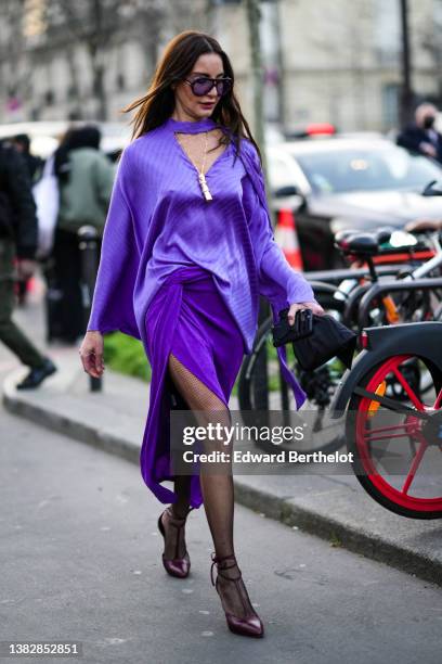 Ece Sukan wears black and purple sunglasses, a purple high neck / cut-out V-neck / oversized silk with inscription print pattern blouse from...