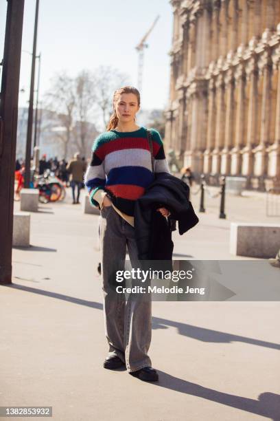 Model Felice Nova Noordhoff wears a multi-color striped cashmere top, gray jeans, black boots at the Sacai show at Hotel de Ville during Paris...