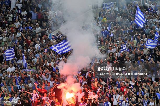 Greek fans celebrate Greece's second goal against Croatia during their qualification match for the Euro 2012 at the Karaiskaki stadium in Piraeues...