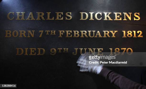 Assistant Restorer Lucy Ackland cleans the gravestone of Charles Dickens at Westminster Abbey on February 1, 2012 in London, England. A wreath laying...