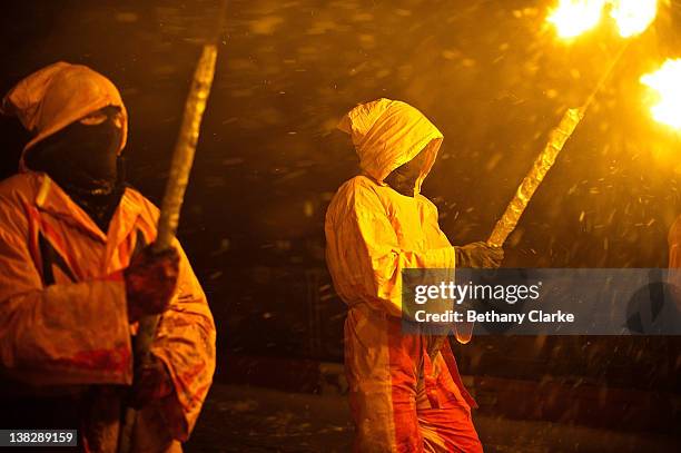 Hooded torch bearers lead the winter procession through the snow on February 4, 2012 in Huddersfield, England. Imbolc is a pagan festival that marks...