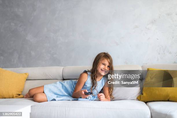 garota feliz relaxando e assistindo tv em casa - girls television show - fotografias e filmes do acervo