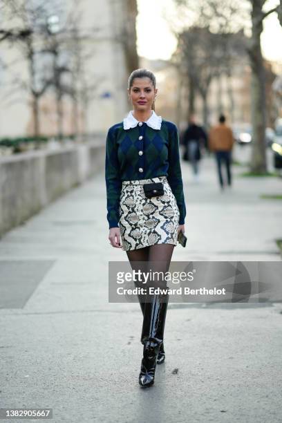 Lala Rudge wears silver and rhinestones earrings, a white shirt with lace collar, a navy blue and dark green checkered / jacquard print pattern...