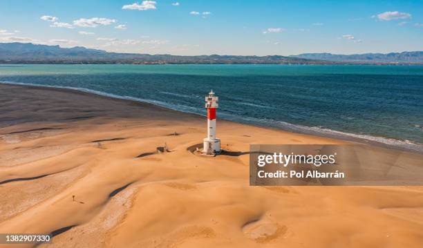 aerial view of the el fangar lighthouse, at the mouth or delta of the ebro river, in tarragona (spain), during a sunny summer day. - ebro river stock-fotos und bilder