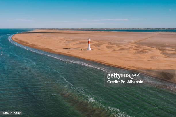 aerial view of the el fangar lighthouse, at the mouth or delta of the ebro river, in tarragona (spain), during a sunny summer day. - ebro river - fotografias e filmes do acervo