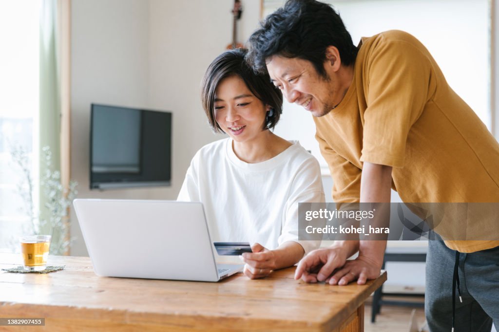 Couple enjoy online shopping at home
