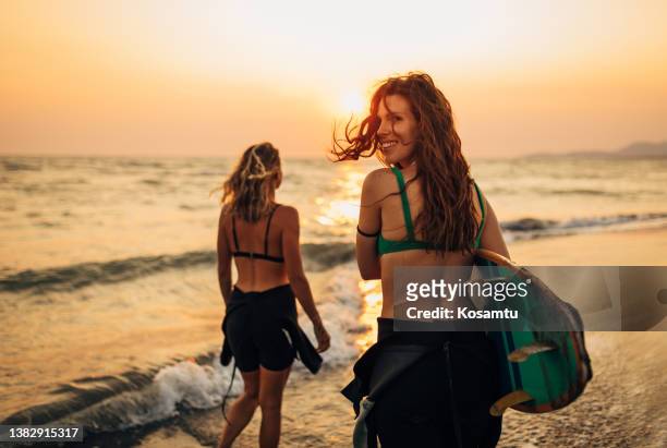 two female surfers running towards the sea. they can't wait to start their surfing adventure today. - can beach sun stock pictures, royalty-free photos & images