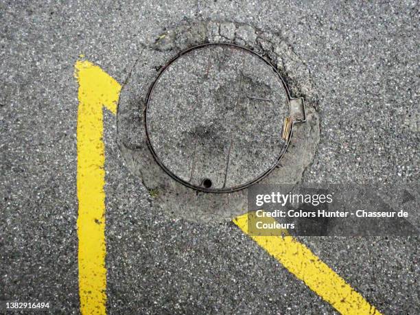 manhole and road marking on an empty street in evian-les-bains - マンホール ストックフォトと画像