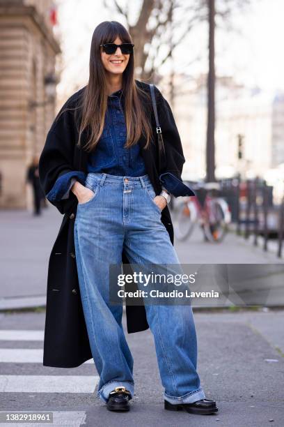 Leia Sfez wearing a navy blue denim shirt, blue jeans, black coat and black bag, is seen outside Sacai, during Paris Fashion Week - Womenswear F/W...